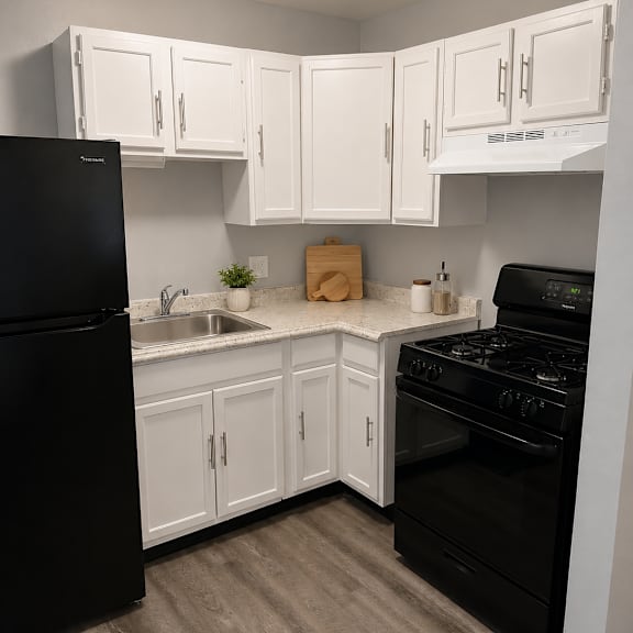 a kitchen with black appliances and white cabinets.