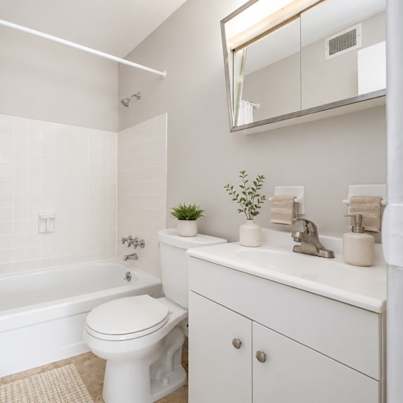 a white bathroom with a toilet, sink, and bathtub.