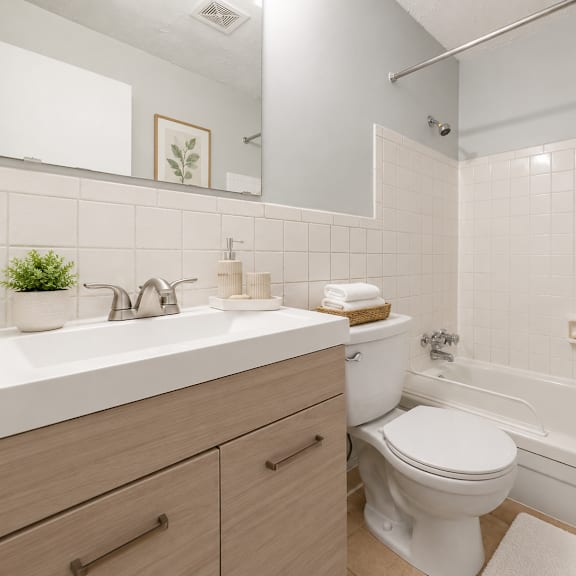 a white bathroom with a toilet, sink, and bathtub.