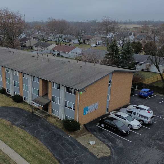 a parking lot in front of a building with cars parked.