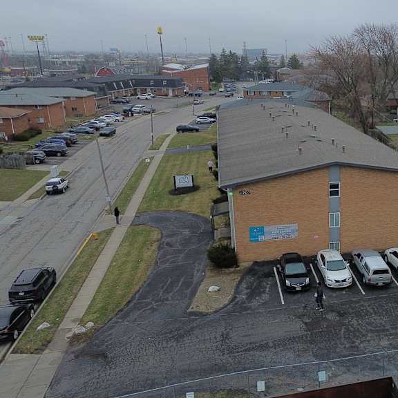 a parking lot with cars and a building in the background.