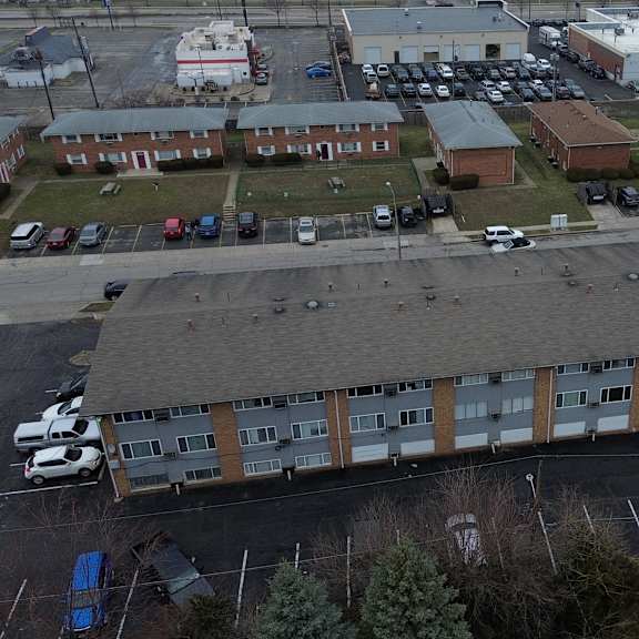 a parking lot with cars and a building in the background.