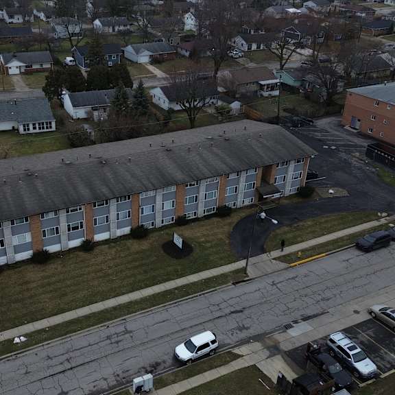 a parking lot with cars and a building in the background.