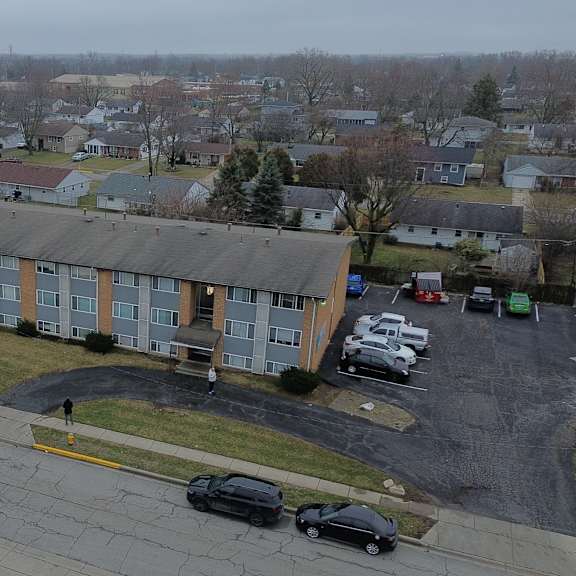 a parking lot with cars and a building in the background.