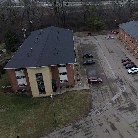 a parking lot with cars and two buildings.