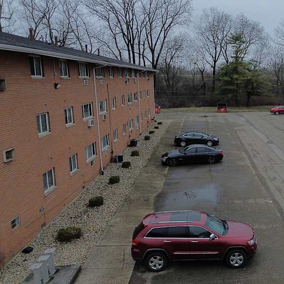 a parking lot with cars and apartment buildings.