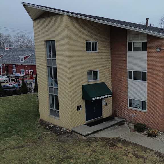 a building with a green awning and a red car parked in front.