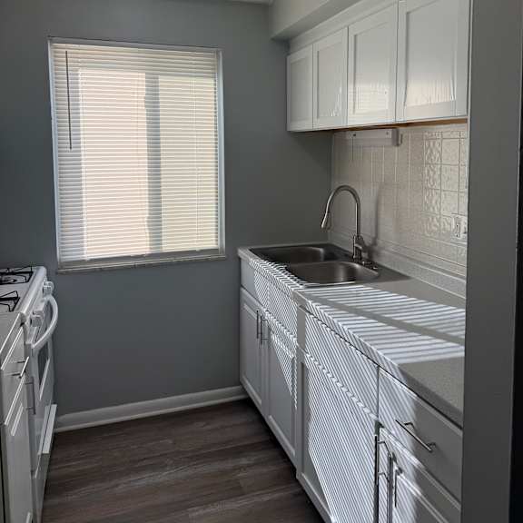a room with a window covered by blinds and a white ceiling with a vent.