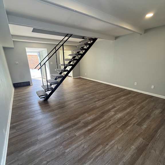a staircase with a wooden floor and a metal railing.