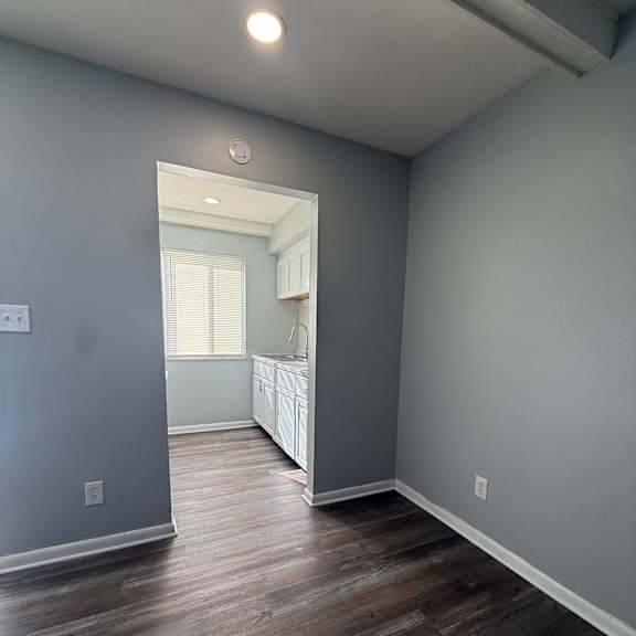 a room with a grey wall and a wooden floor.