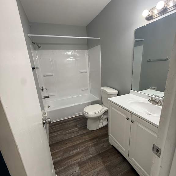 a bathroom with a toilet, sink, and mirror.