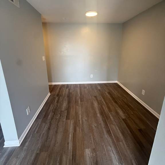 a room with a grey floor and a wooden wall.