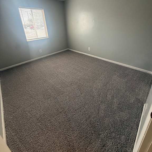 a small window in a room with a grey wall.