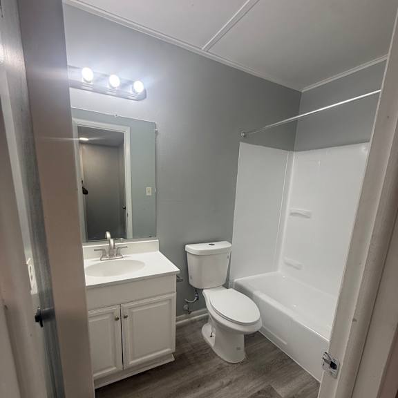 a bathroom with a toilet, sink, and mirror.
