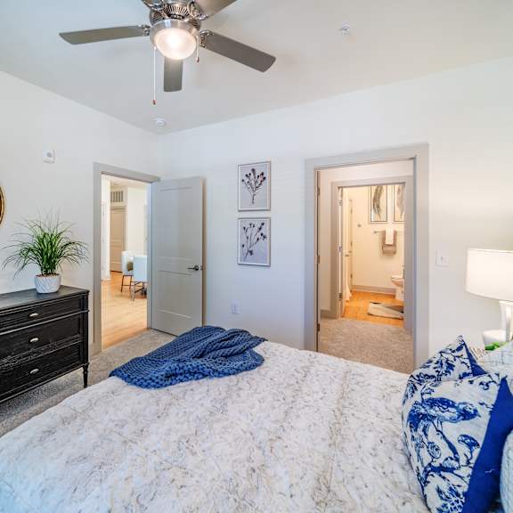 bed and dresser in a carpeted bedroom of an independent living apartment in huntersville, nc