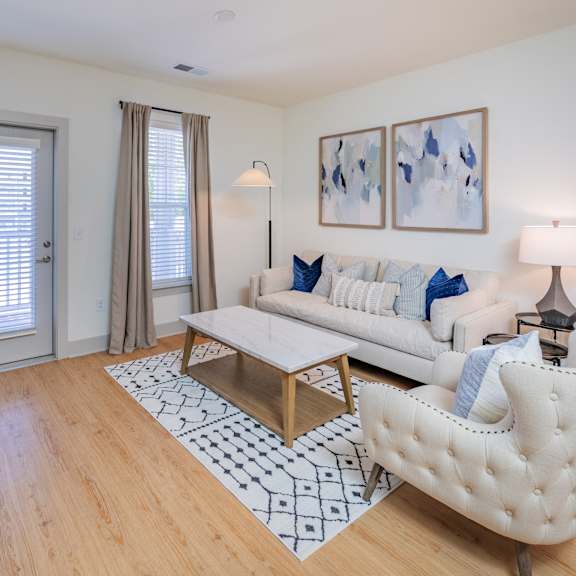a living room with a white couch and a door leading to a private balcony