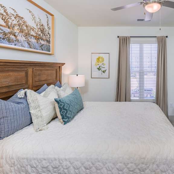 carpeted bedroom with a ceiling fan and window coverings