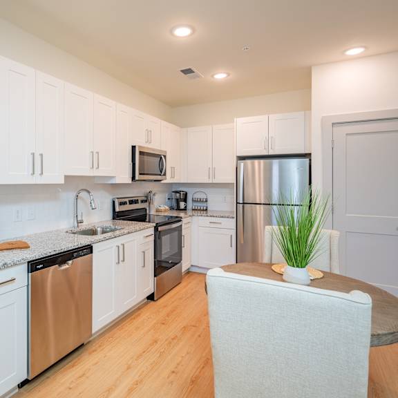 a kitchen with white cabinets and stainless steel appliances