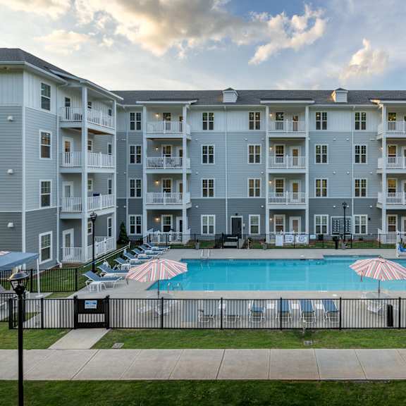exterior view of the arden at huntersville 55+ community apartment building and swimming pool
