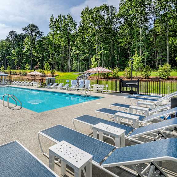 blue lounge chairs beside an outdoor swimming pool