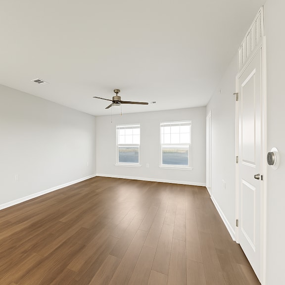 Thumbnail 3 of 3 A room with a ceiling fan and wooden floors.