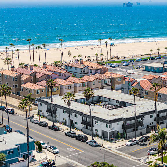 a beachfront town with a large body of water and a ship in the distance.