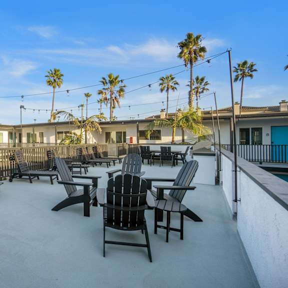 a patio with chairs and palm trees at ocean breeze terrace apartment, california