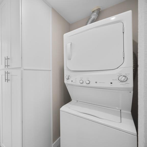 a white dryer is sitting in a laundry room.