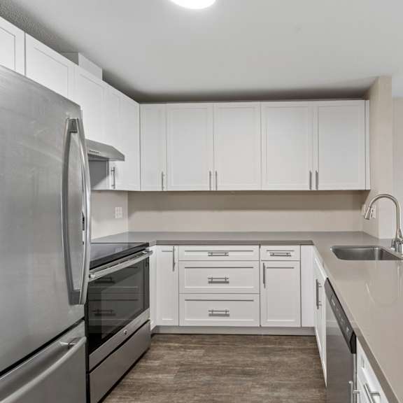 a kitchen with white cabinets and a stainless steel refrigerator.
