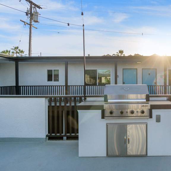 a white outdoor kitchen with a grill and sink at ocean breeze terrace apartment, california