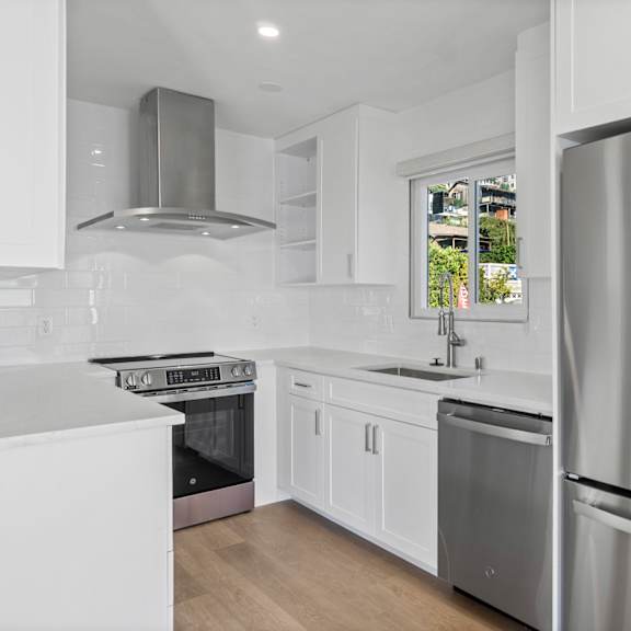 a modern kitchen with white cabinets and stainless steel appliances.at ocean edge @ laguna beach, laguna beach, ca 92651