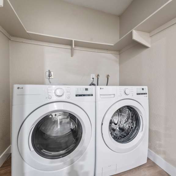 two white front loading washing machines in a laundry room.