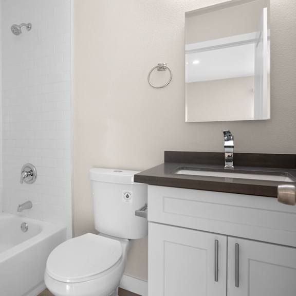 a white bathroom with a toilet, sink, and tub.