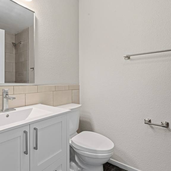 a white bathroom with a toilet, sink, and medicine cabinet.