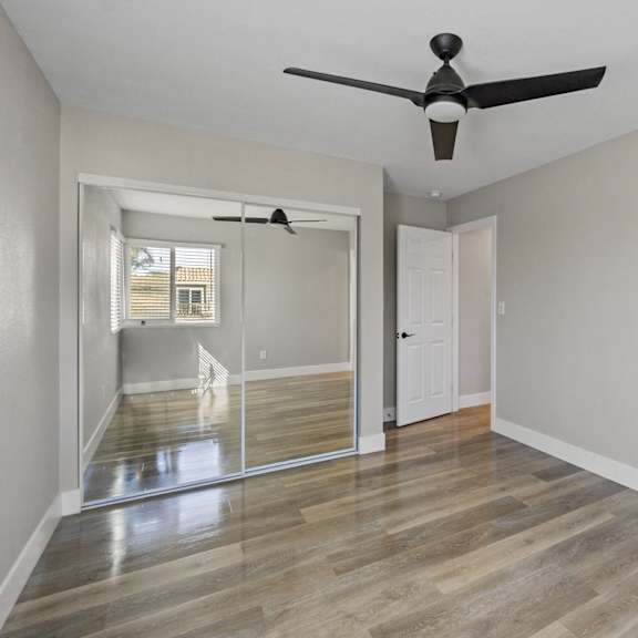an empty living room with a ceiling fan and a window at ocean breeze terrace apartment, california, 92648