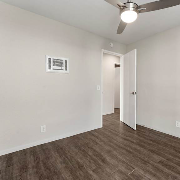 a room with a ceiling fan and a door.