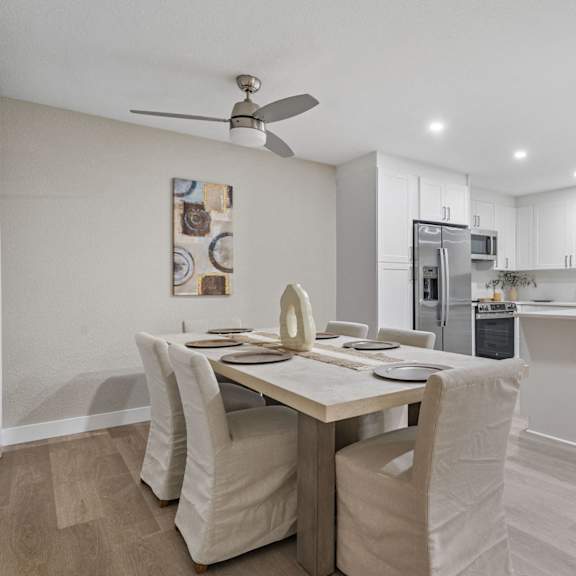 a modern kitchen with a dining table and chairs at tamarack sands apartment homes, carlsbad, ca
