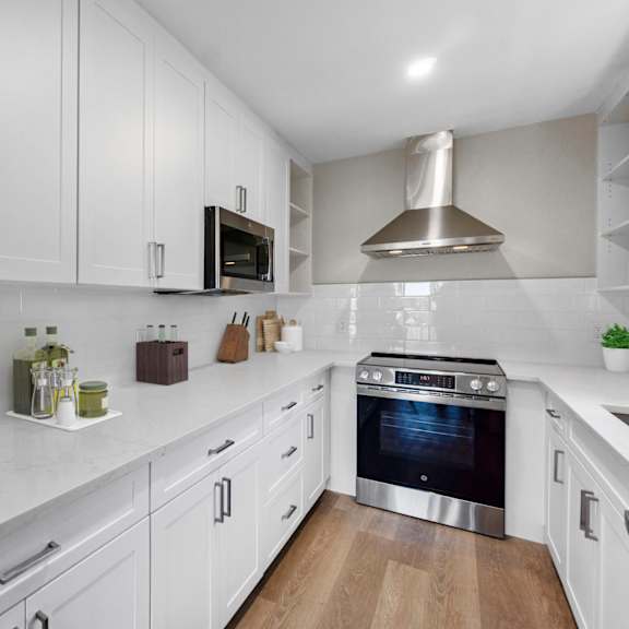 a modern kitchen with white cabinets and a stainless steel oven.at ocean edge @ laguna beach, california, 92651