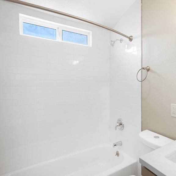 a bathroom with a tub sink and shower and a mirror at huntington manor homes apartment, huntington beach, ca, 92648