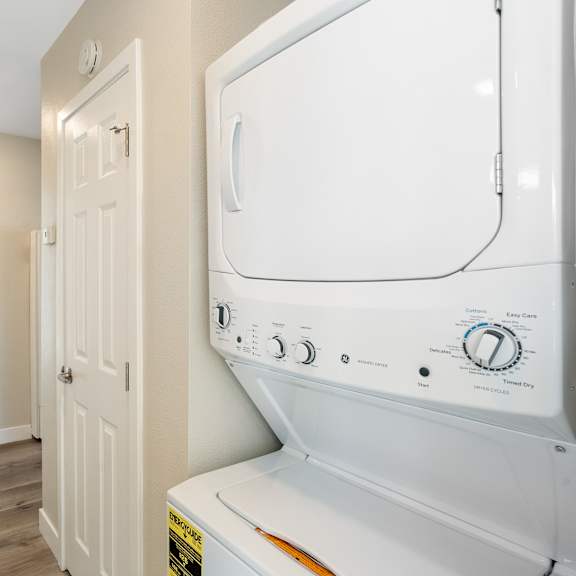 a laundry room with a washer and dryer and a hallway with a door at huntington manor homes apartment, california, 92648