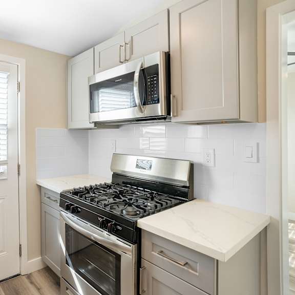 an empty kitchen with a stove and a microwave at huntington manor homes apartment, huntington beach, ca