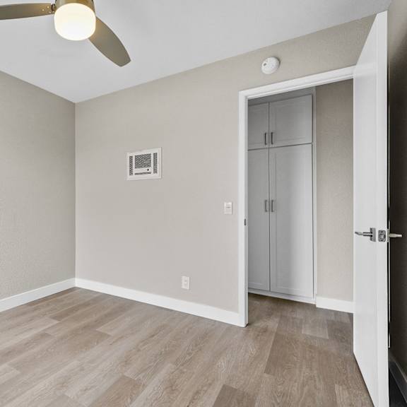 a room with a ceiling fan and a door leading to another room at tamarack sands apartment homes, carlsbad, ca, 92008