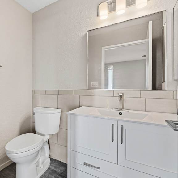a white toilet sits next to a sink in a bathroom.