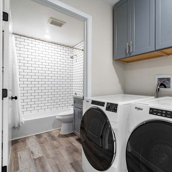 a washer and dryer in a laundry room with a sink and a toilet