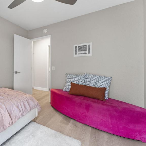 a bedroom with a pink bed and a pink bench at tamarack sands apartment homes, carlsbad, 92008