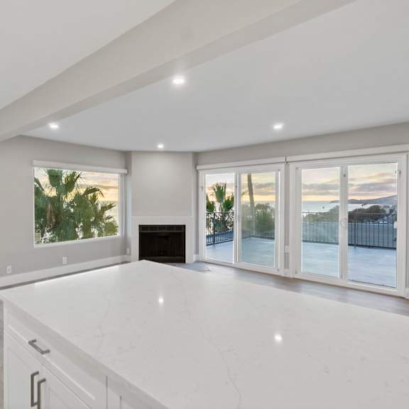 a spacious living room with a fireplace and sliding glass doors.at ocean edge @ laguna beach, california