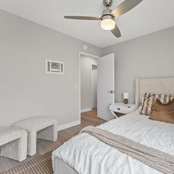 a bedroom with a bed, pillows, and a ceiling fan at tamarack sands apartment homes, carlsbad, ca, 92008