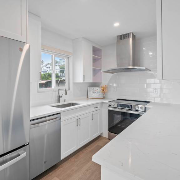 a modern kitchen with white appliances and cabinets.