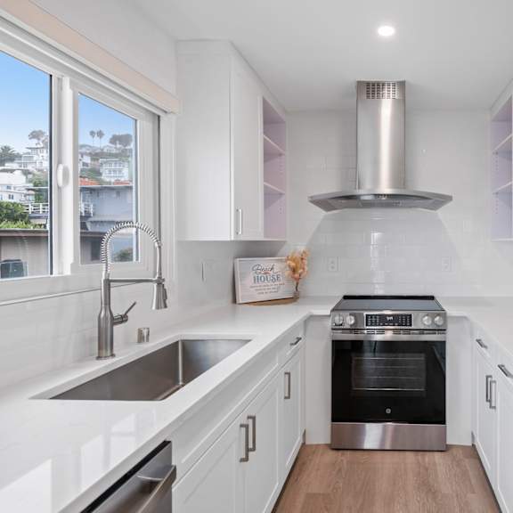 a modern kitchen with white cabinets and stainless steel appliances.