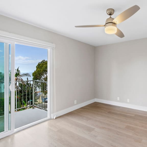 a room with a ceiling fan and sliding glass doors.at ocean edge @ laguna beach, laguna beach california